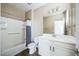 Bright bathroom with white vanity, a shower-tub combo, and wood-look tile flooring at 42256 W Lucera Ln, Maricopa, AZ 85138