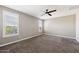 Large bedroom features carpet, ceiling fan, and natural light from multiple windows with plantation shutters at 42256 W Lucera Ln, Maricopa, AZ 85138