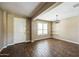 Bright living area features wood floors, ample natural light from window, and elegant lighting fixture at 42256 W Lucera Ln, Maricopa, AZ 85138