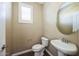 Powder room with pedestal sink, toilet, wood look tile flooring, and single window at 42256 W Lucera Ln, Maricopa, AZ 85138