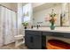 Well-lit bathroom featuring a vanity with a sleek black faucet and decorative plants at 4332 N 197Th Dr, Litchfield Park, AZ 85340