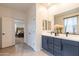 Bathroom view with dual sinks, vanity, and an open doorway to the main bedroom at 4332 N 197Th Dr, Litchfield Park, AZ 85340