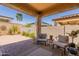 Inviting covered patio with brick flooring, comfortable seating, and decorative plants at 4332 N 197Th Dr, Litchfield Park, AZ 85340