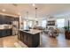 Open concept kitchen with granite countertops, stainless appliances, island, and view into the adjacent living area at 4332 N 197Th Dr, Litchfield Park, AZ 85340