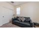 Comfortable living room with a stylish couch, neutral carpet, and a bright window at 4332 N 197Th Dr, Litchfield Park, AZ 85340