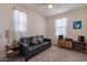 Bright living room with comfortable black leather sofa, entertainment center, and plenty of natural light at 4332 N 197Th Dr, Litchfield Park, AZ 85340