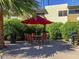 Outdoor patio area offers a comfortable seating arrangement with a red umbrella and a barbecue grill at 4610 N 68Th St # 472, Scottsdale, AZ 85251