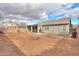 Wide backyard featuring a covered patio, partial privacy fence, and neighboring houses at 46175 W Morning View Ln, Maricopa, AZ 85139