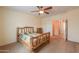 Spacious bedroom with a log bed, ceiling fan, and access to the ensuite bathroom at 46175 W Morning View Ln, Maricopa, AZ 85139