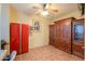 Neutral room with a red cabinet, ceiling fan and built in wood cabinet on tile floor at 46175 W Morning View Ln, Maricopa, AZ 85139