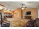 Cozy living room featuring tile floors, an open kitchen, and a comfortable leather sofa at 46175 W Morning View Ln, Maricopa, AZ 85139