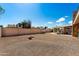 Wide backyard showcasing desert landscaping, block fence, and covered patio for ideal outdoor enjoyment at 4619 E Farmdale Ave, Mesa, AZ 85206