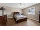 Cozy bedroom featuring a wooden bed frame, plantation shutters, and tile flooring with neutral paint at 4619 E Farmdale Ave, Mesa, AZ 85206