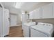 Functional laundry room with washer, dryer, and ample cabinet space with tile flooring at 4619 E Farmdale Ave, Mesa, AZ 85206