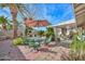 Backyard featuring a patio with comfortable seating under an umbrella, surrounded by lush greenery at 5223 W Acoma Dr, Glendale, AZ 85306