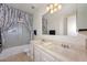 Well-lit bathroom featuring a double sink vanity, large mirror, and shower-tub combination at 5223 W Acoma Dr, Glendale, AZ 85306