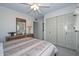 Bedroom featuring a ceiling fan, dresser with mirror, and a closet with paneled doors at 5223 W Acoma Dr, Glendale, AZ 85306