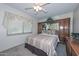 Comfortable bedroom featuring carpet floors, a ceiling fan and a window with decorative curtains at 5223 W Acoma Dr, Glendale, AZ 85306