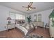 Cozy main bedroom featuring laminate floors, a ceiling fan and a large window for natural light at 5223 W Acoma Dr, Glendale, AZ 85306