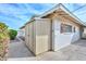 The exterior view of a neutral toned shed has double doors and is attached to the property at 5223 W Acoma Dr, Glendale, AZ 85306