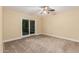 Simple bedroom with a ceiling fan, carpet flooring, and a sliding glass door at 6036 E Windsor Ave, Scottsdale, AZ 85257