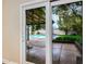 Bedroom view through glass doors showcases a refreshing pool and patio area at 6036 E Windsor Ave, Scottsdale, AZ 85257