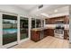 Open kitchen with granite countertops and stainless appliances adjacent to outdoor pool area at 6036 E Windsor Ave, Scottsdale, AZ 85257