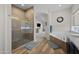 Bathroom featuring glass-enclosed shower, soaking tub, wood look flooring, and view into main bedroom at 686 E Vermont Dr, Gilbert, AZ 85295