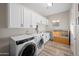 Functional laundry room with washer, dryer, ample storage cabinets and a built-in sink at 686 E Vermont Dr, Gilbert, AZ 85295