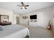 Spacious main bedroom featuring a ceiling fan, television, and ensuite bathroom at 686 E Vermont Dr, Gilbert, AZ 85295