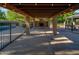 Cozy covered patio with stone fireplace, string lights, and views of the pool and backyard at 7216 W Country Gables Dr, Peoria, AZ 85381