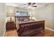 Cozy bedroom with a wooden bed frame, ceiling fan, and hardwood flooring at 7216 W Country Gables Dr, Peoria, AZ 85381