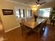 Bright dining room featuring a wooden table, ceiling fan, and window shutters at 7216 W Country Gables Dr, Peoria, AZ 85381