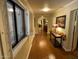 Hallway featuring an arched doorway, wood-look floors, and a window with white shutters at 7216 W Country Gables Dr, Peoria, AZ 85381