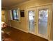 Open living area with double doors leading to an outdoor space and shuttered windows at 7216 W Country Gables Dr, Peoria, AZ 85381