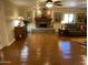 Cozy living room with hardwood floors, stone fireplace, and a comfortable leather couch at 7216 W Country Gables Dr, Peoria, AZ 85381