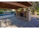 Covered patio features a beautiful outdoor fireplace perfect for entertaining and relaxation near the pool at 7216 W Country Gables Dr, Peoria, AZ 85381