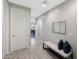 Well-lit hallway with wood-look tile flooring, a bench with pillows, and a view into the adjacent open-concept kitchen at 738 W Kingman Dr, Casa Grande, AZ 85122