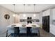 Kitchen island with a sink, pendant lighting, seating, and white cabinets provides functional workspace and gathering spot at 738 W Kingman Dr, Casa Grande, AZ 85122