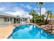 Relaxing backyard features a clear blue pool, palm trees, and lush landscaping at 8027 E Quarterline Rd, Mesa, AZ 85207