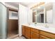 Well-lit bathroom featuring a double vanity, large mirror, and tiled walk-in shower at 8027 E Quarterline Rd, Mesa, AZ 85207