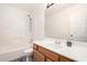 Well-lit bathroom with wood vanity and tub with shower at 8027 E Quarterline Rd, Mesa, AZ 85207