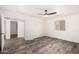 Bright bedroom featuring wood-look flooring, ceiling fan, and easy access to other rooms at 8027 E Quarterline Rd, Mesa, AZ 85207