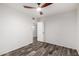 Bedroom with ceiling fan, wood-look floors, and a door at 8027 E Quarterline Rd, Mesa, AZ 85207