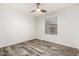 Bedroom with wood-look floors, ceiling fan, and window at 8027 E Quarterline Rd, Mesa, AZ 85207