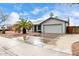 Exterior view of a one-story home, featuring a two-car garage, gravel landscaping, and a large palm tree at 8027 E Quarterline Rd, Mesa, AZ 85207