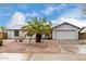 Charming single-story home featuring a well-maintained front yard with a palm tree and a two-car garage at 8027 E Quarterline Rd, Mesa, AZ 85207