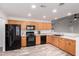 Functional kitchen with black appliances, warm wood cabinetry, and durable countertops, offering ample space at 8027 E Quarterline Rd, Mesa, AZ 85207