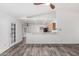 Inviting living space with wood-look floors, a ceiling fan, and a view of the kitchen with bar seating at 8027 E Quarterline Rd, Mesa, AZ 85207