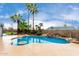 Backyard pool featuring a serene waterfall feature, beautifully landscaped with palm trees and ample space at 8027 E Quarterline Rd, Mesa, AZ 85207